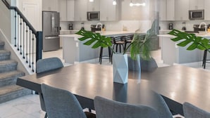 A modern kitchen with stainless steel appliances, a central island, and pendant lighting. - 9BR house with private pool in Champions Gate (Kissimmee)