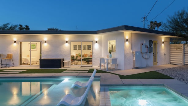 Ein modernes Haus mit Schwimmbad, Rutsche und einer Terrassenfläche.