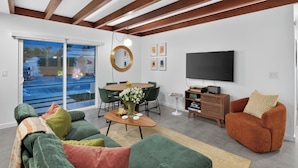 Ein modernes Wohnzimmer mit Sofa, Couchtisch und Fernseher.