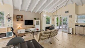 Un salon moderne avec un téléviseur, un canapé, une table basse et une bibliothèque.