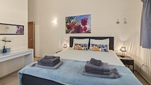 Une chambre à coucher avec un lit, des lampes de chevet, un tableau et un miroir.