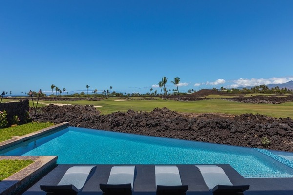 Enjoy a refreshing dip in the pool with a serene golf course view, perfect for a sunny afternoon.