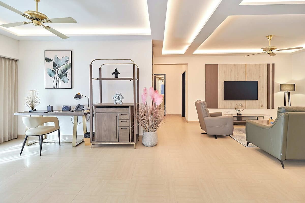 Una sala de estar moderna con escritorio, sofá y televisor.