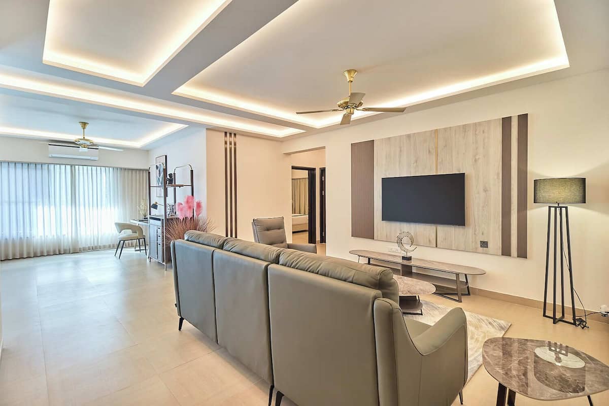 Una sala moderna con sofá, televisor y comedor.