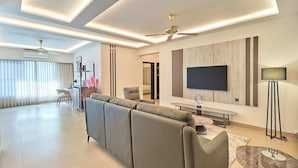 Una sala moderna con sofá, televisor y comedor.