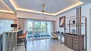 Una habitación de hotel moderna con balcón, escritorio y zona de estar.