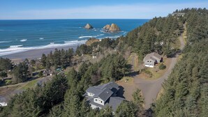 Une propriété située sur la côte, comprenant une grande maison, une allée et une vue sur la plage.