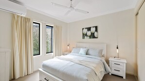 A bedroom with a bed, nightstands, a ceiling fan, and a window with curtains. - El Penguini in Cowes (Cowes)