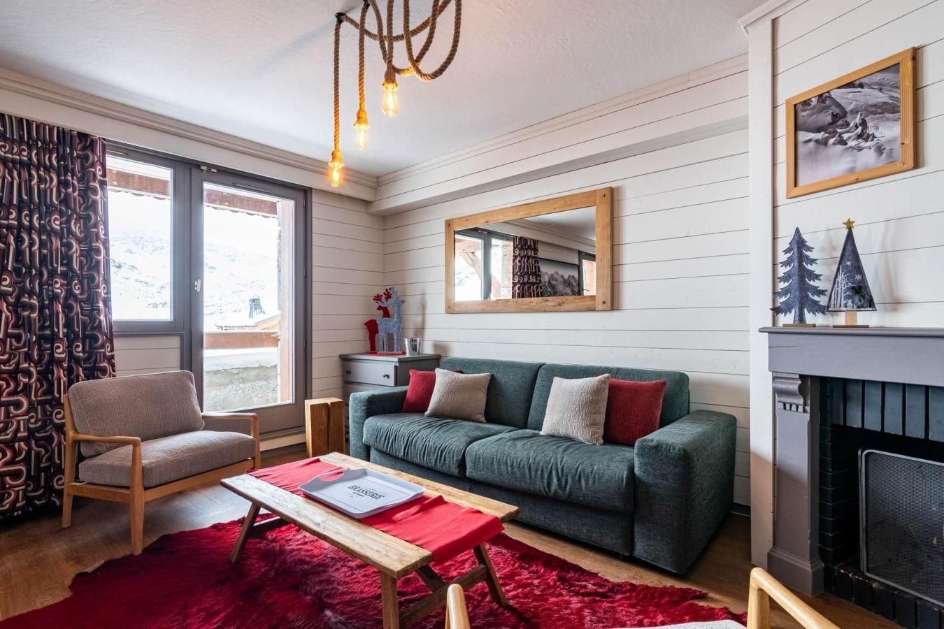 A cozy living room with a green sofa, wooden coffee table, and a fireplace.