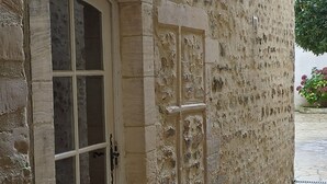 A stone building with a large arched doorway and a small window. - Bayeux, Appartement Le Clem's'right in the heart of town and tourist sites. (Bayeux)