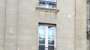 A building with a storefront labeled "NK" and a large poster of a man in a suit. - Bayeux, Appartement Le Clem's'right in the heart of town and tourist sites. (Bayeux)