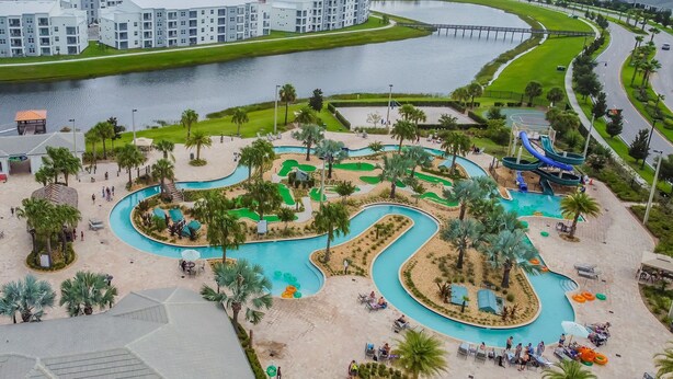 A resort with a large pool area, palm trees, and a water park. - 5BR Storey Lake Home, Heated Pool (kissimmee)