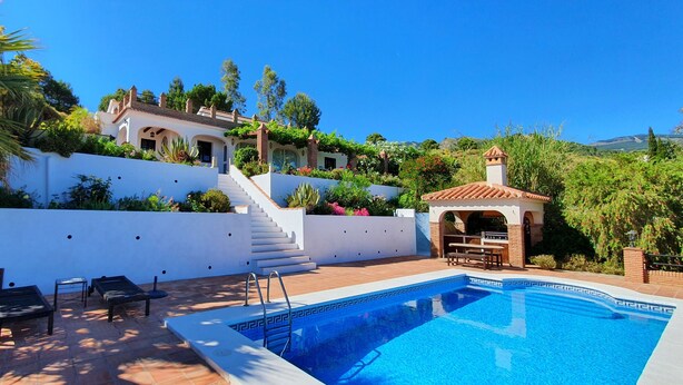 A pool area with a clear blue pool, a set of stairs leading to a house, and outdoor seating. - Villa Los Almendros (Canillas de Albaida)