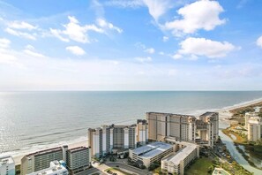 Un paisaje urbano costero con edificios altos, una playa y un río.
