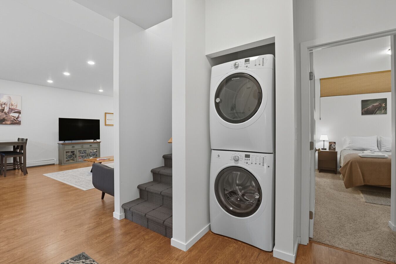 A modern apartment with a laundry room featuring two stacked front-loading washing machines.