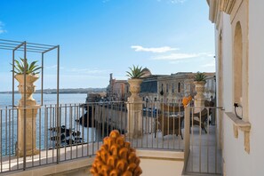 A balcony with a view of the sea and historic buildings. - Maniace Boutique Hotel Ortigia UNA Esperienze (Syracuse)