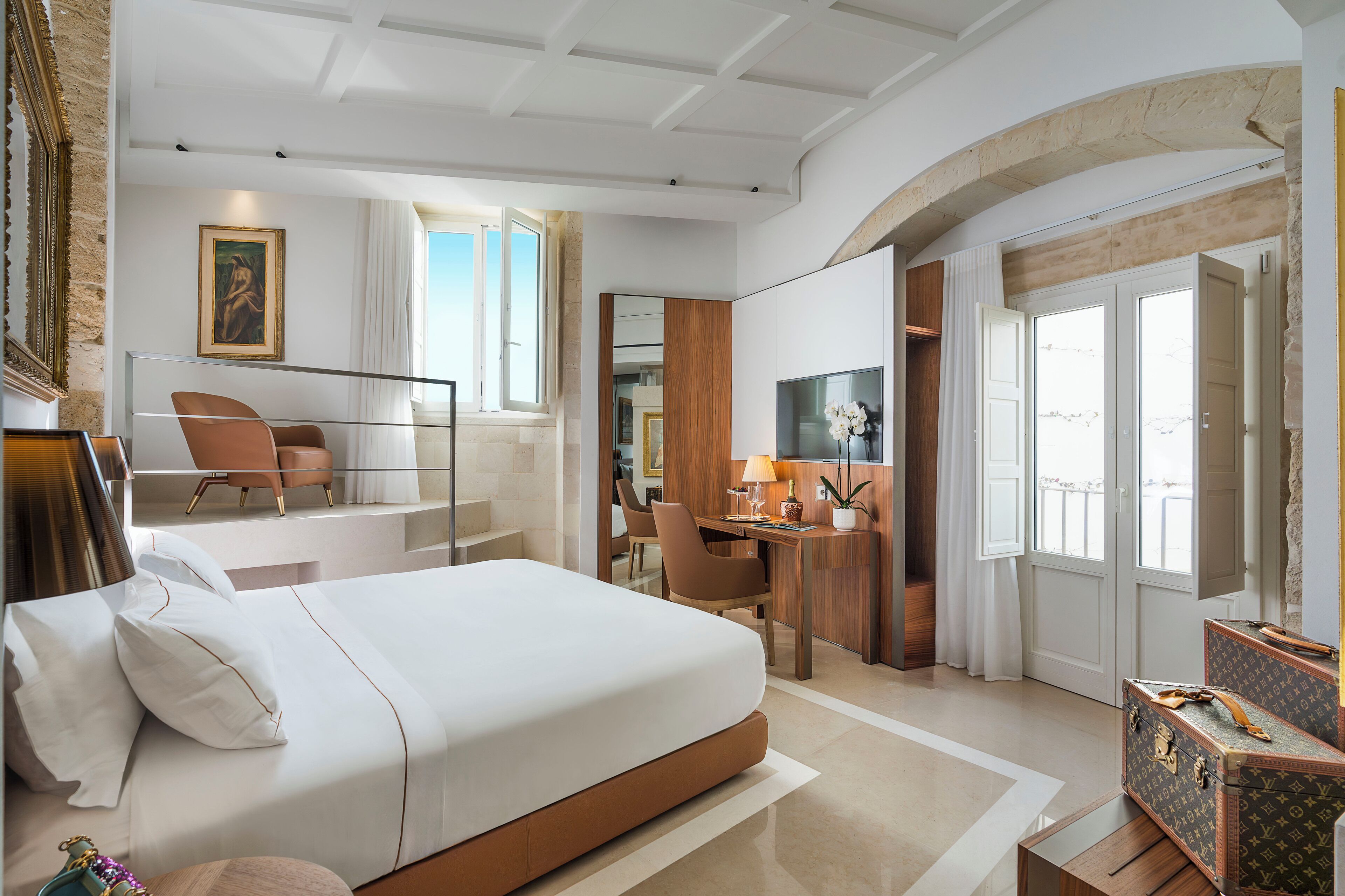 Een moderne hotelkamer met een groot bed, een bureau en een zithoek.