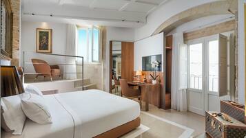 Een moderne hotelkamer met een groot bed, een bureau en een zithoek.