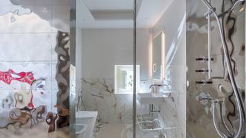 Un bagno moderno con cabina doccia in vetro, pavimento in marmo e lavabo bianco.
