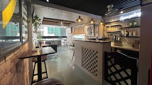 Um restaurante com área de bar, mesas e vista para a rua.