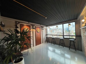 Una habitación con un ventanal grande, un dardo y una planta en maceta.