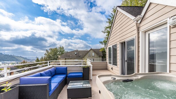 A rooftop terrace with a hot tub, blue outdoor furniture, and a view of the city. - Majestic Views with a Hot Tub! (Seattle)