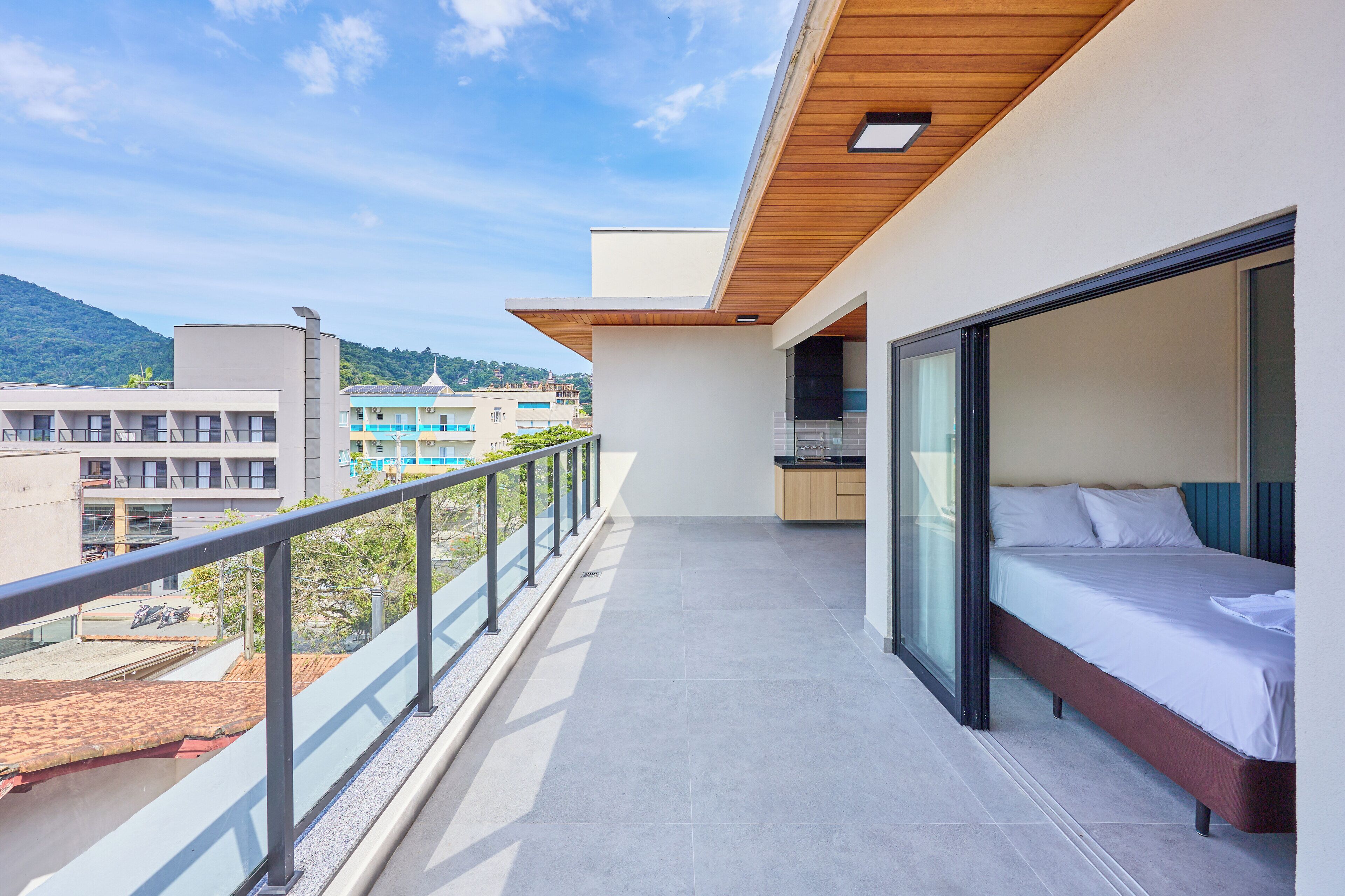 Een moderne hotelkamer met balkon, een bed en uitzicht op de stad.