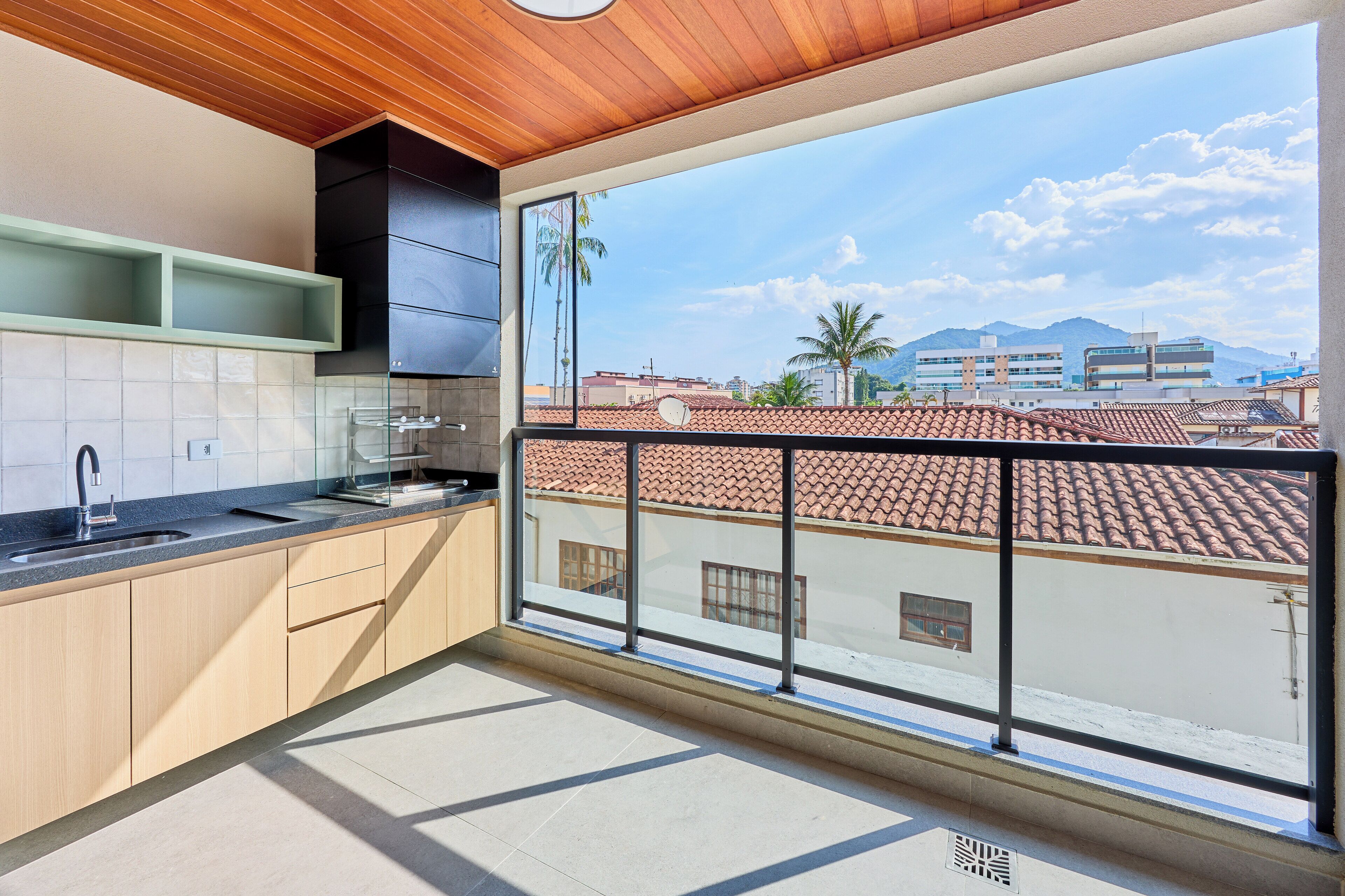 A modern kitchen with a large window, wooden ceiling, and tiled floor.