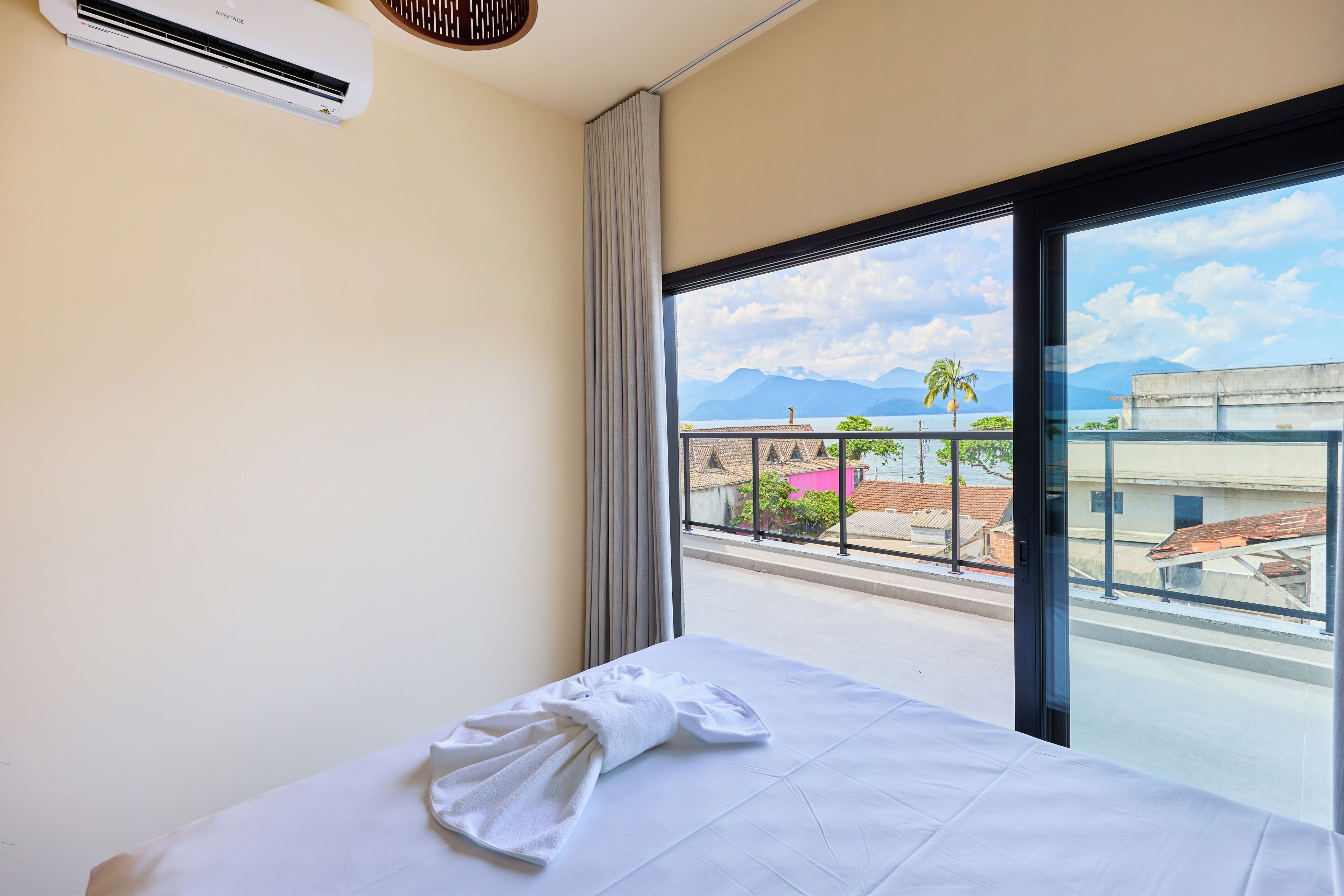Una habitación de hotel con cama, ventana y aire acondicionado.