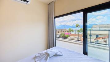Una habitación de hotel con cama, ventana y aire acondicionado.