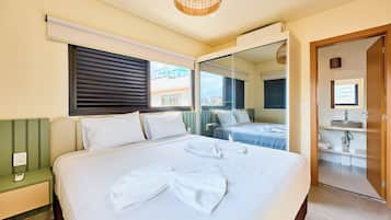 A hotel room with a large bed, a bedside table with a phone, a mirror, and a view of the outside.