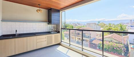 A modern kitchen with a large window overlooking a cityscape.