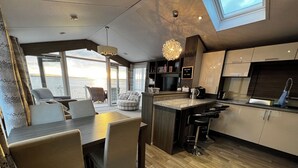 Une cuisine moderne dotée d’un îlot central, de tabourets de bar et offrant une vue sur la mer.