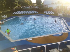 A swimming pool with multiple lanes, a lifeguard stand, and a deck area with lounge chairs.