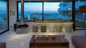 Uma sala de estar moderna com uma janela grande, uma lareira e uma mesa de centro de madeira.