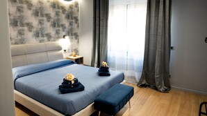 Une chambre moderne avec un grand lit, des tables de chevet et une fenêtre avec des rideaux.