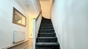 Una escalera con peldaños alfombrados que conduce a una plataforma.