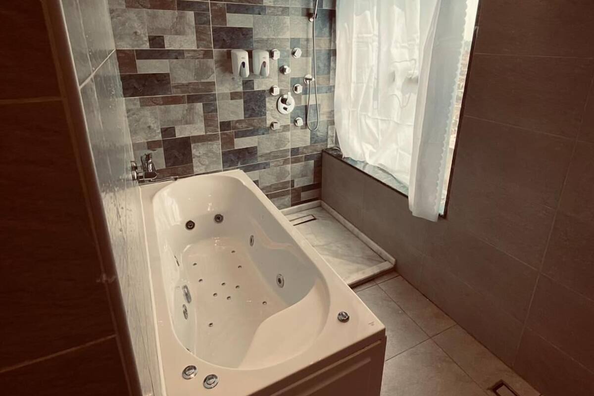 A modern bathroom with a freestanding bathtub, a shower, and a tiled backsplash.