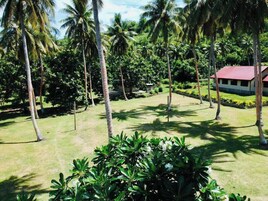 Un paisaje tropical con palmeras y un edificio de techo rojo.