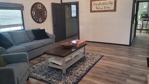 Ein Wohnzimmer mit einer Couch, einem Couchtisch und einer Wanduhr.