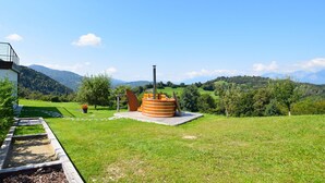 A grassy area with a wooden structure and a view of mountains.