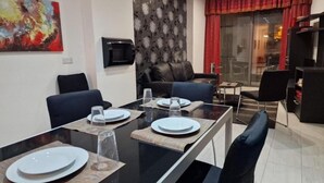 A modern living room with a dining area. - Bugibba Central Modern Apartment, Charming 2-bedroom apartment with AC,  WiFi  (San Pawl il-Baħar)
