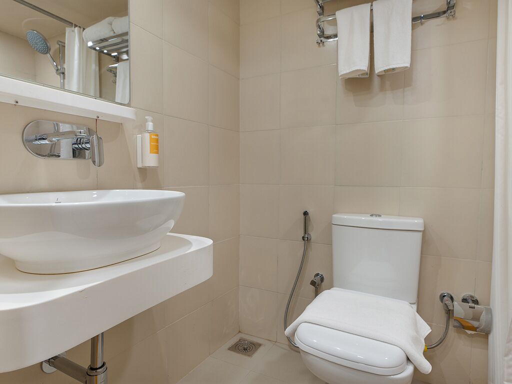 A bathroom with a white sink, toilet, and shower.