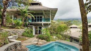 A modern house with a swimming pool surrounded by natural landscape and trees. - Casa Maracuya (San Mateo)