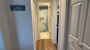 A hallway with wooden flooring, white walls, and a door on the right. - Gulfside Getaway - Newly renovated waterfront 3-bedroom w/dock in Port Richey (Port Richey)