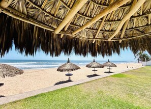 A beach with thatched umbrellas and a clear view of the ocean. - Beautiful beach house with private pool in Cerritos Mazatlan for up to 12 people. (Mazatlán)