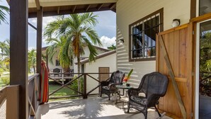 Un patio cubierto con mobiliario de mimbre y una palmera.