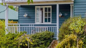A house with a porch, a window, and a number '59' on the wall.