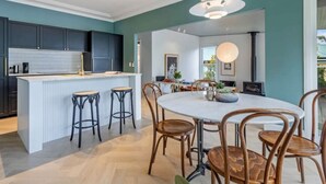 A modern kitchen with dark cabinets, a white island, and bar stools.