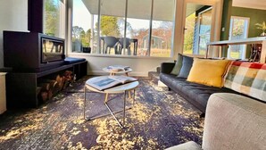 A modern living room with a fireplace, a sofa, and a coffee table.